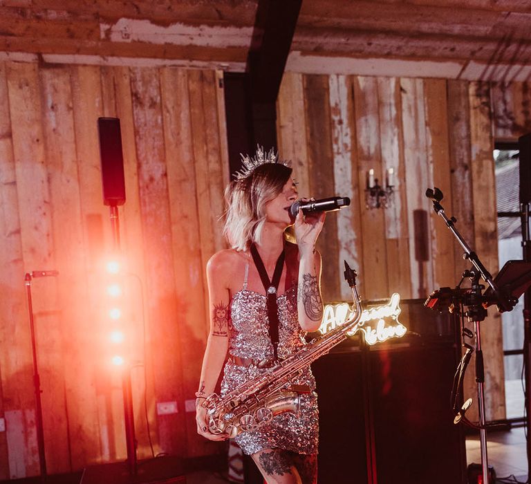 Wedding singer and saxophone player in sequin dress performing at wedding 