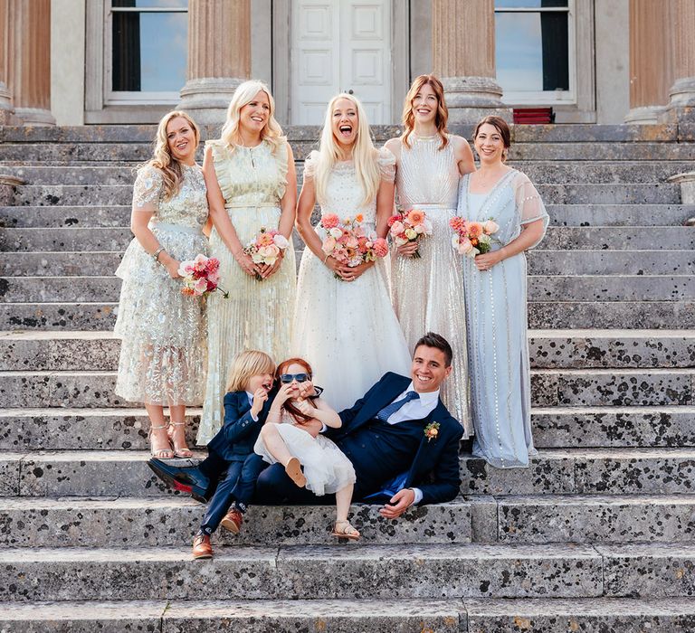 Bridal party wearing metallic bridesmaid dresses with the bride, groom and page boy 