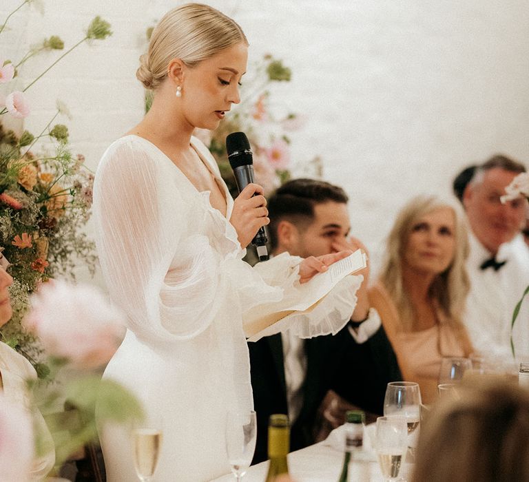 Bride stands to read out bridal speech 