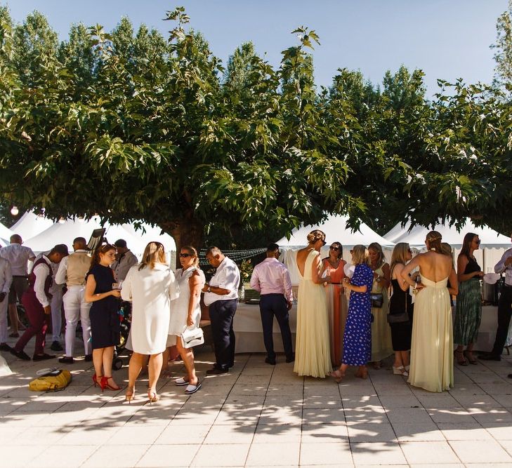 Guests enjoy drinks outside the Bordeaux wedding venue