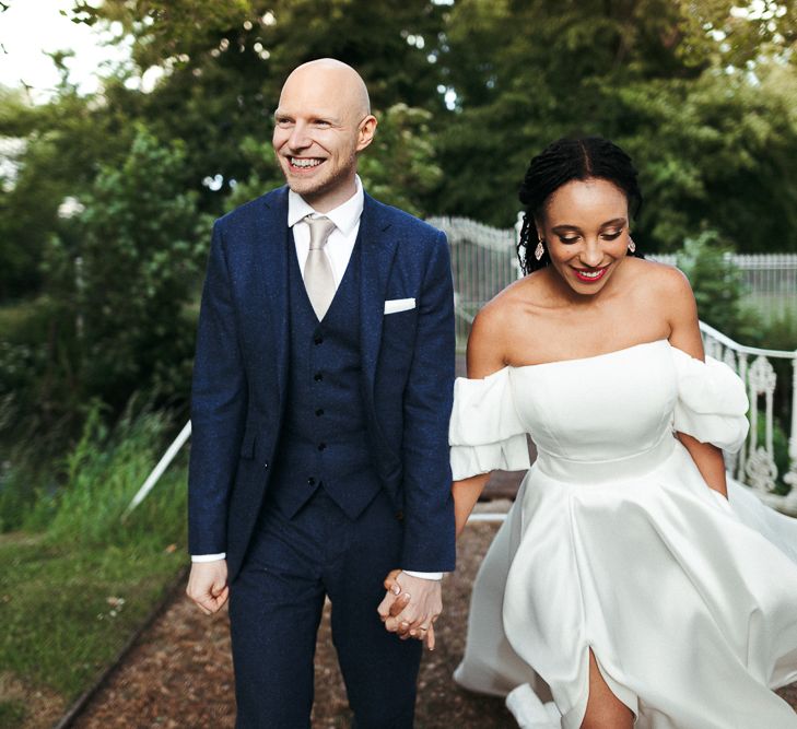 Bride and groom holding hands at Morden Hall wedding 