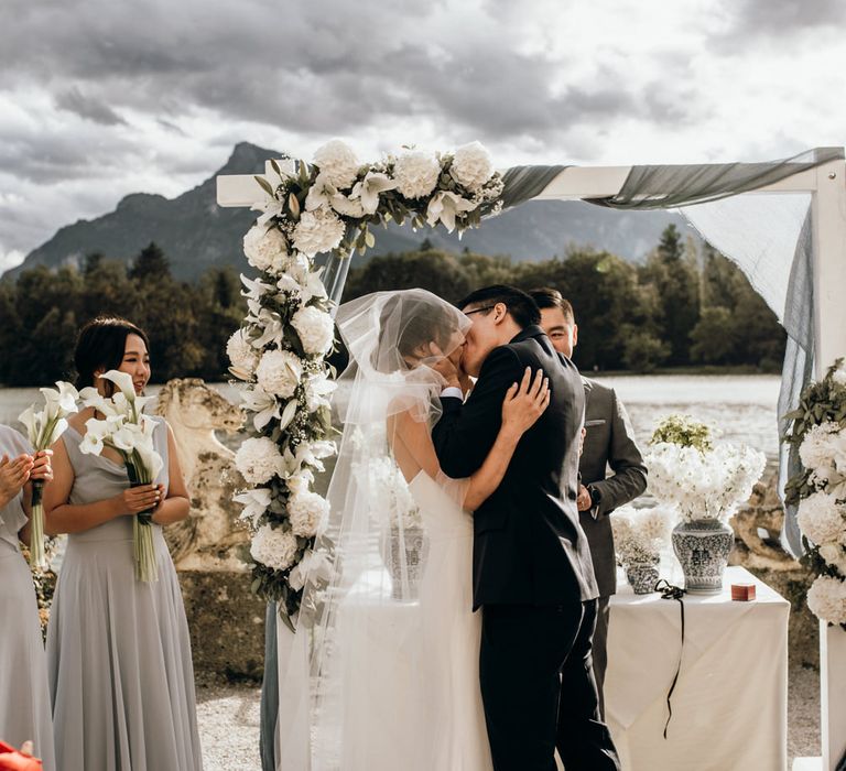 Bride and groom kissing at the altar with white flower in blue and white Chinese pottery 