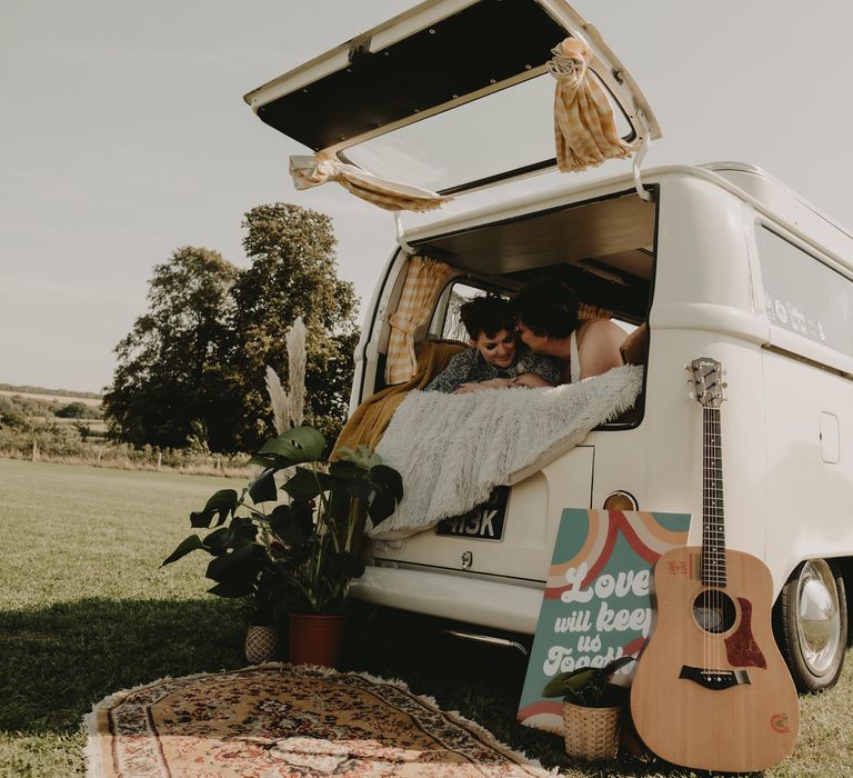 Brides sitting together in a camper van at LGBT wedding 