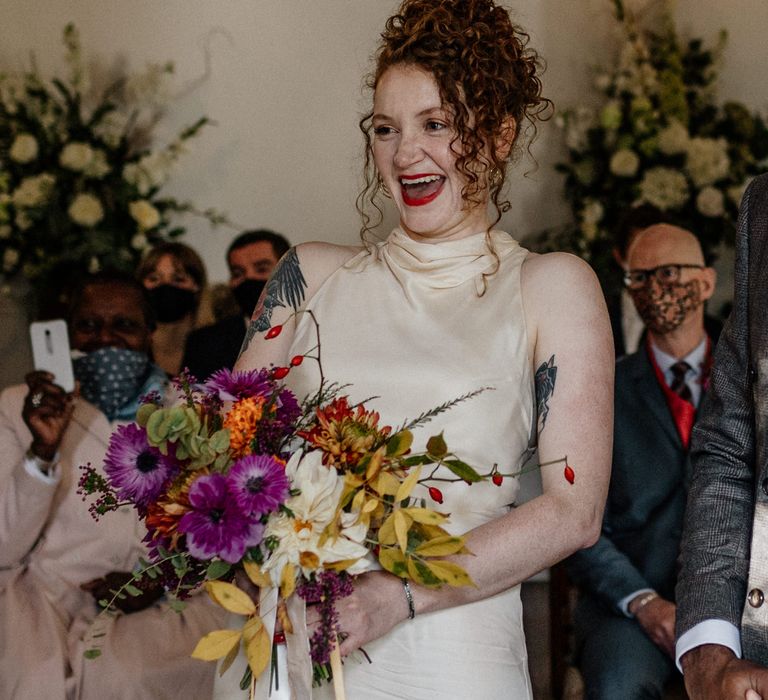 Beautiful bride with bright bouquet at London pub wedding