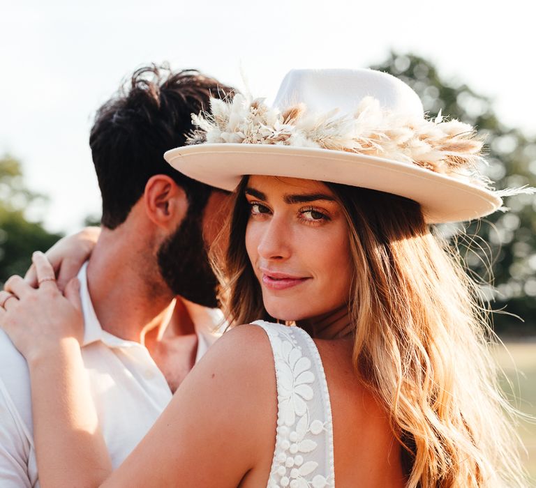 Bride looks back wearing bridal hat 