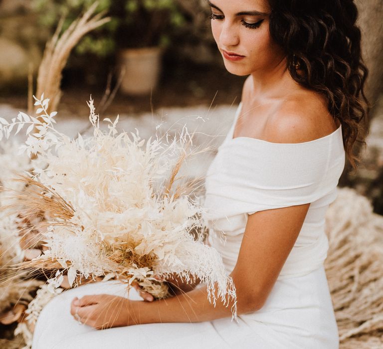 Dark haired bride wearing off the shoulder wedding gown