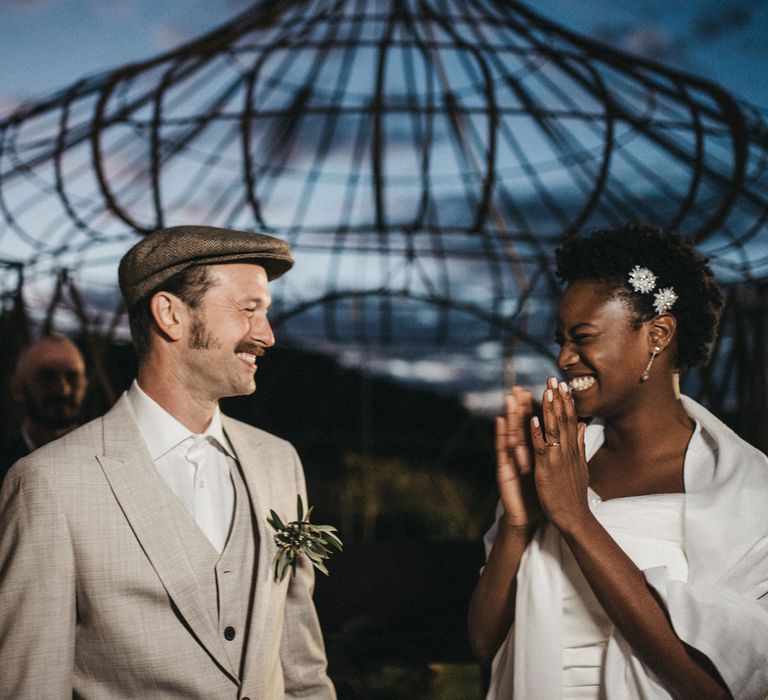 Portrait of the bride and groom clapping and smiling at their outdoor wedding ceremony at Les Bonnes Joies, Nr. Paris, France 