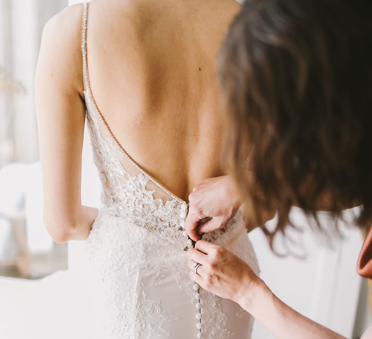 Bride has her dress done up on the morning of her wedding