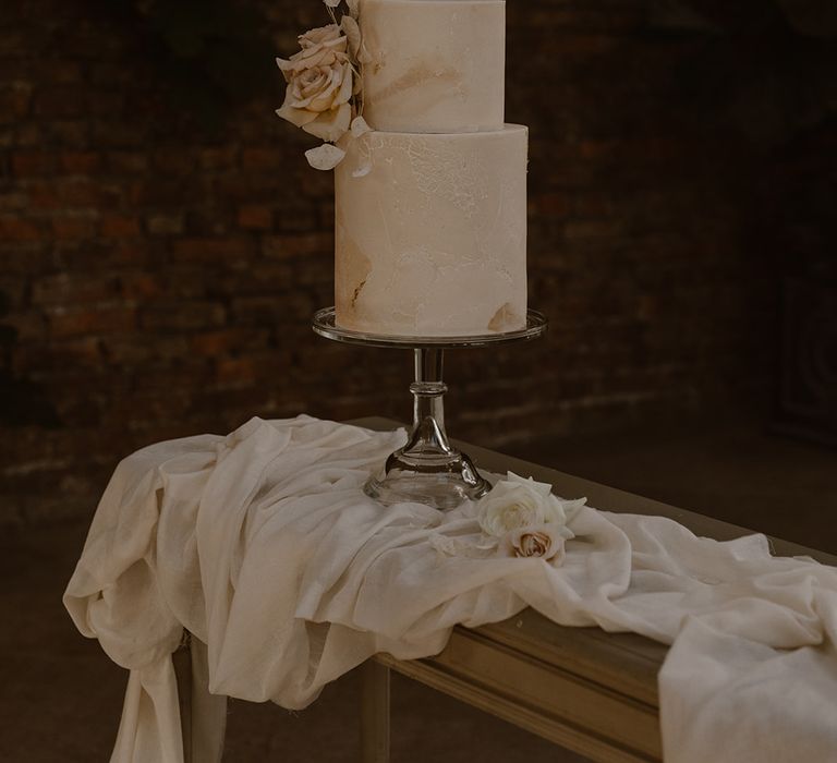 Two tiered off white marble effect wedding cake with rose decoration by Bohemian Bakehouse