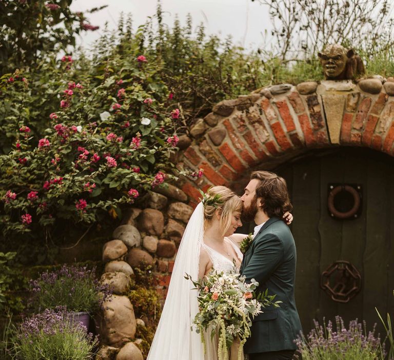 Bride & groom embrace outdoors at botanical themed wedding