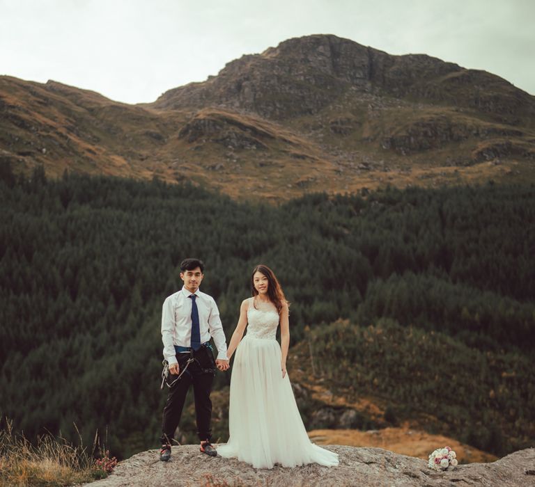 Couple stand together whilst dark haired girl wears white dress 