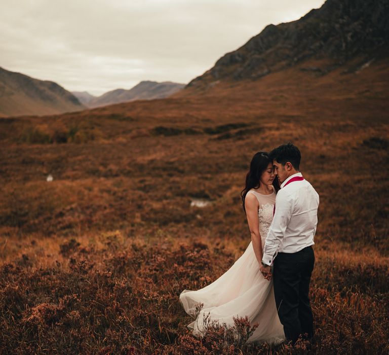 Couple stand within the countryside of Scotland during engagement session