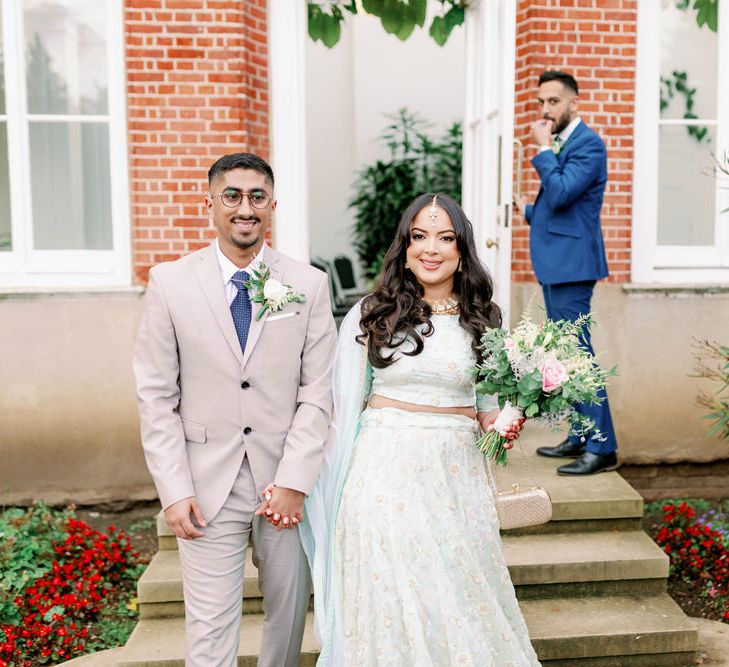 Bride and groom holding hands at Islam and Sikh interfaith wedding 