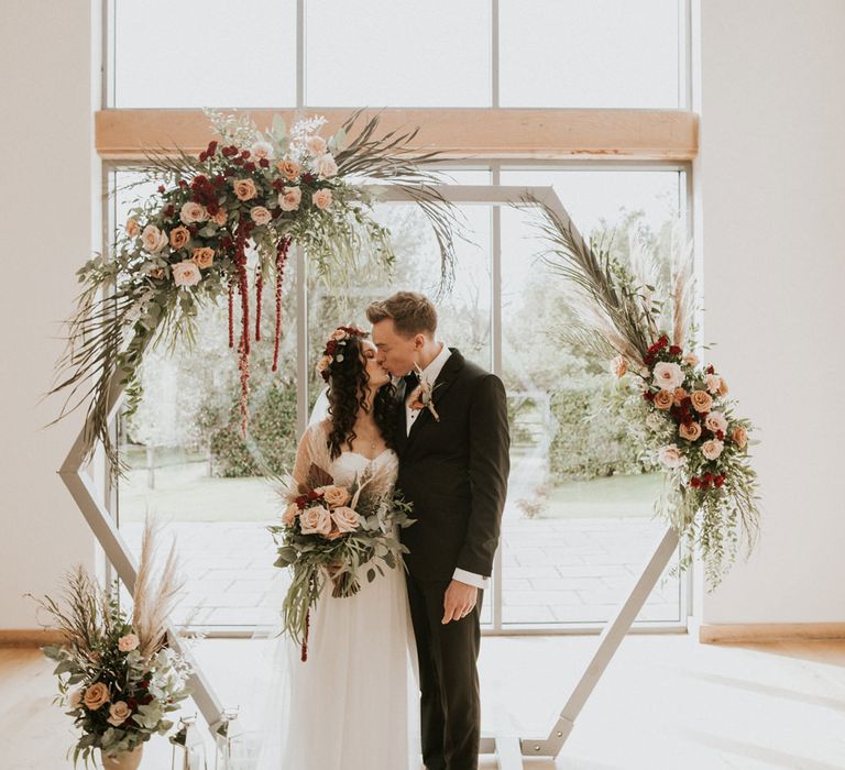 Bride and groom kissing at the altar of their Intimate Millbridge Court wedding 