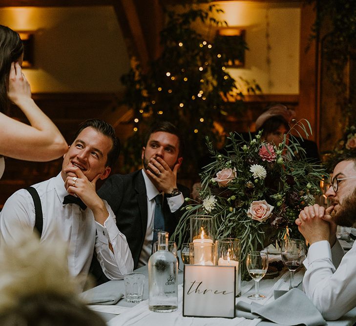 Bride in a strapless wedding dress with jewel belt detail and cathedral length veil talking to her wedding guests