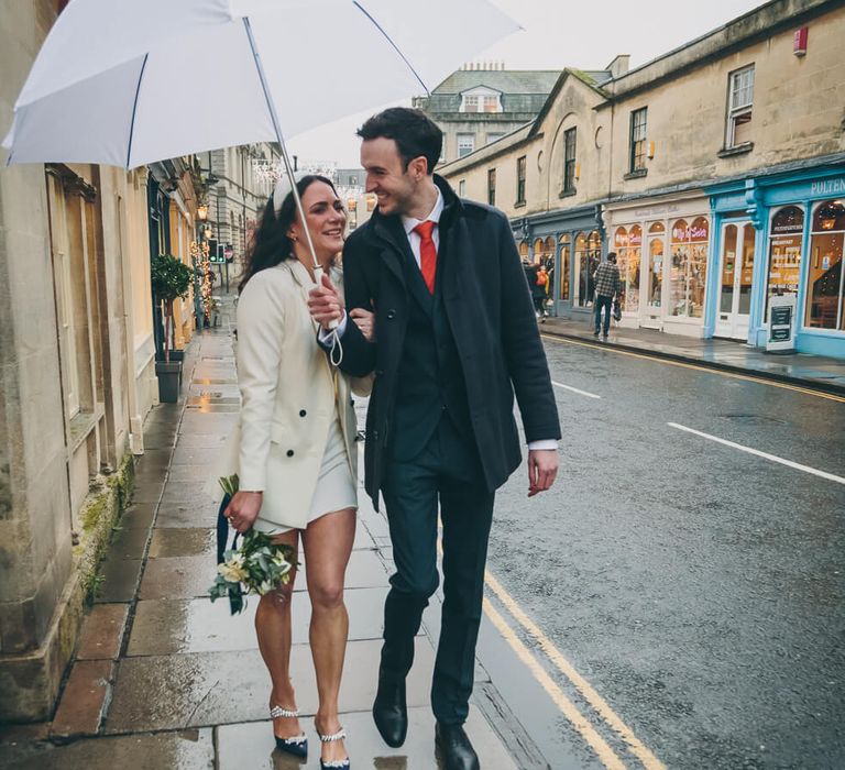 Bride and groom walking in the rain