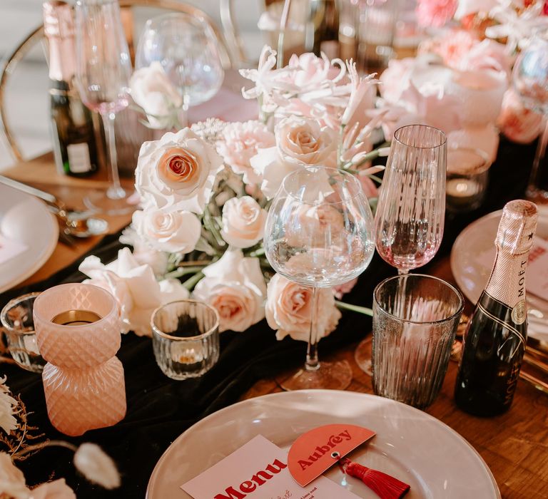 Place setting with retro menu car and name place card, iridescent glassware and blush pink floral arrangements 