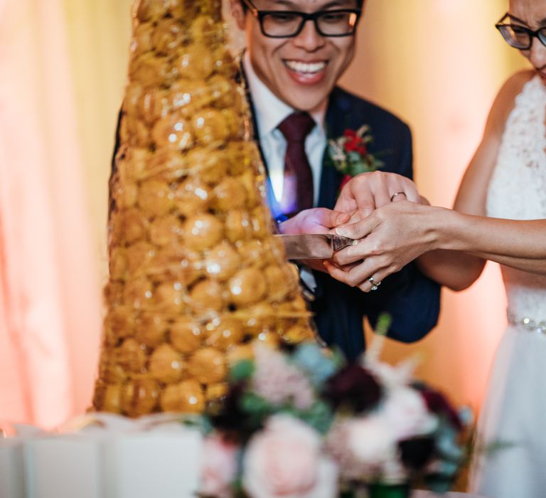 Bride & groom cut through croquembouche