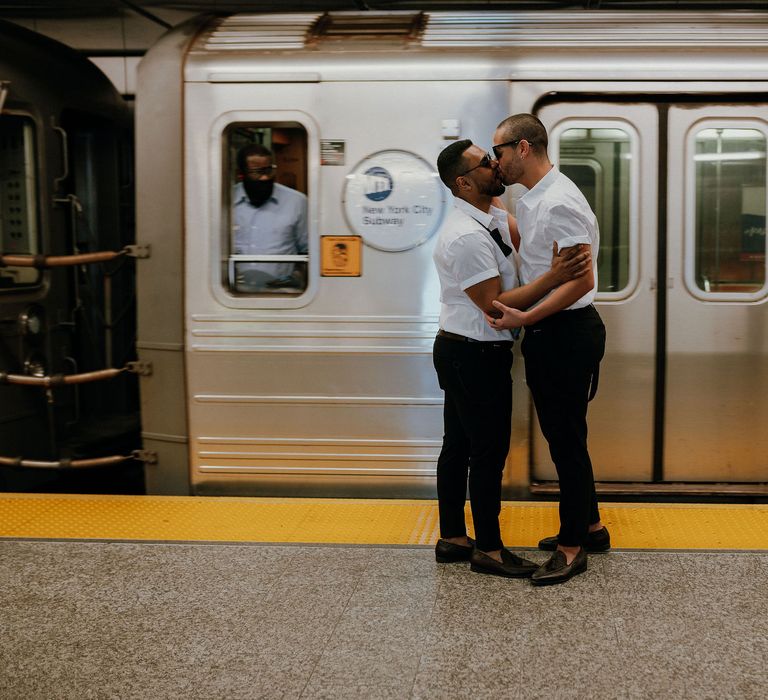 Grooms kiss on the subway at New York wedding