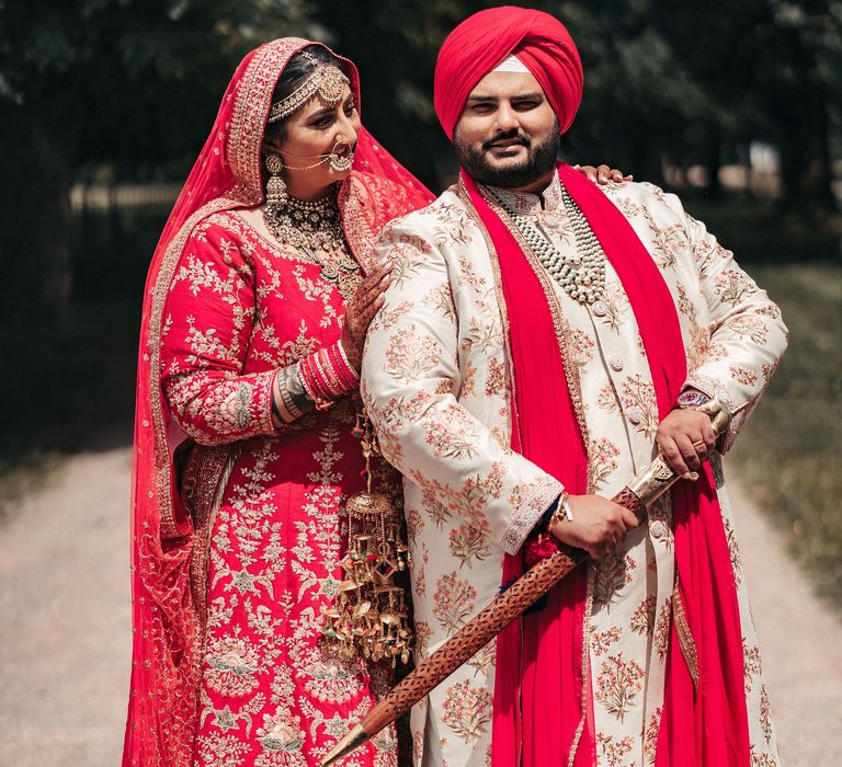 Bride & groom stand together outdoors on the day of their wedding 