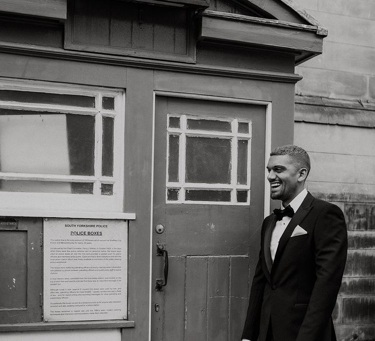 Stylish groom in a tuxedo standing outside an old South Yorkshire Police station