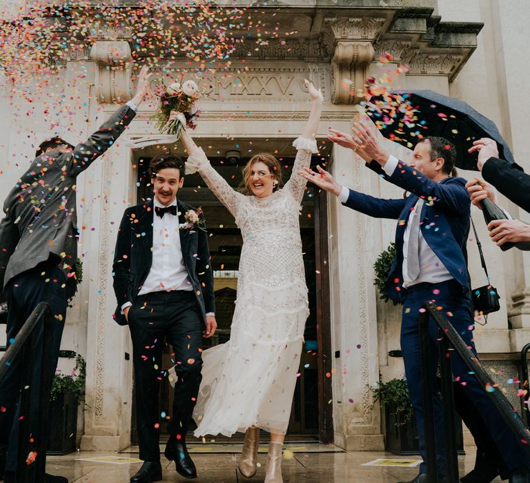 Bride & groom celebrate as they leave Town Hall after marriage on their wedding day