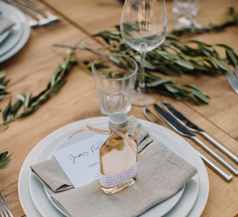 Cloth napkin complete with wedding favours in small bottle tied with string