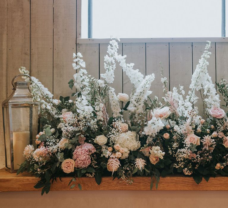 White and blush pink floral cloud with foliage and candles in glass candle holders in wedding ceremony room at Primrose Hill Farm 