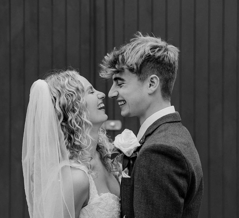 Black & white image of bride & groom looking lovingly at one another outdoors on their wedding day