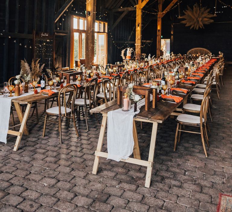 Fairy lights, pampas grass, autumnal colour dinner place settings at Boho wedding Elmley Nature Reserve