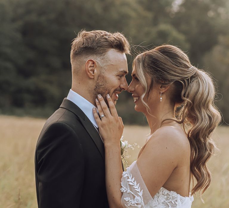 Bride & groom embrace outdoors in field on their wedding day