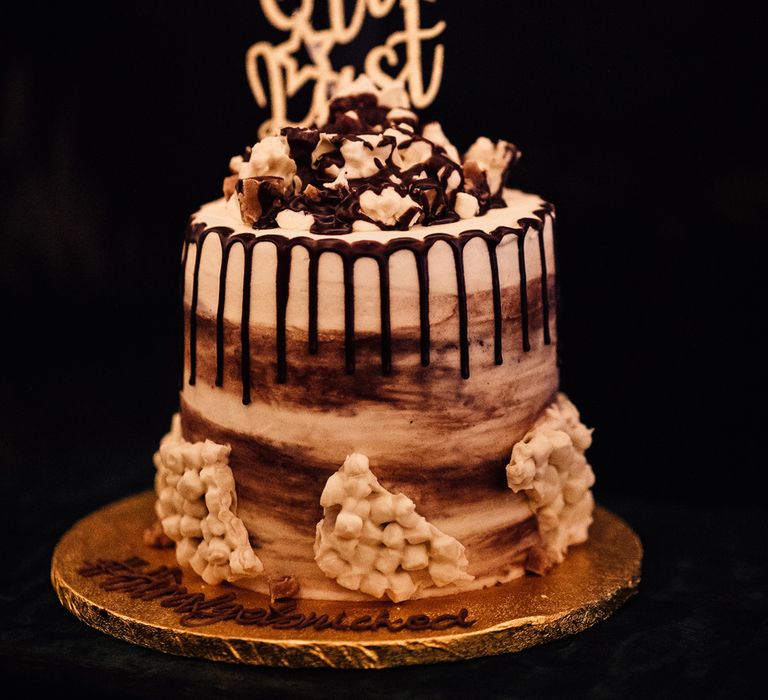 Semi-naked chocolate drop effect wedding cake with wedding cake topper reading 'At Last'