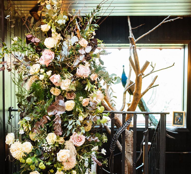 White and pink roses and greenery in large flower display at pub wedding venue in Essex