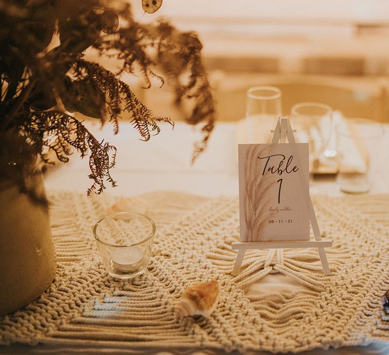 Personalised table sign on small white card with date of wedding and pattern on white wooden stand