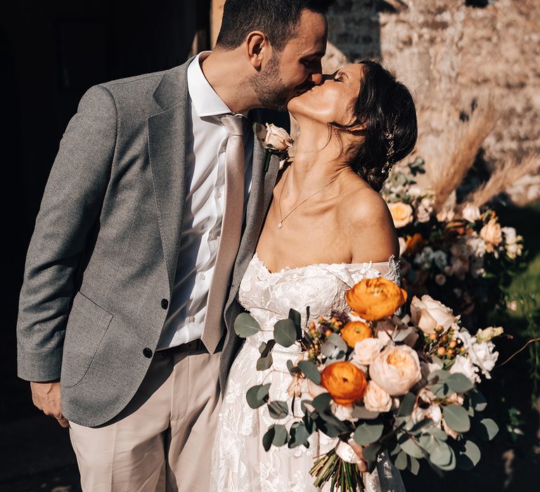 Bride and groom share an intimate kiss outside of their church wedding venue