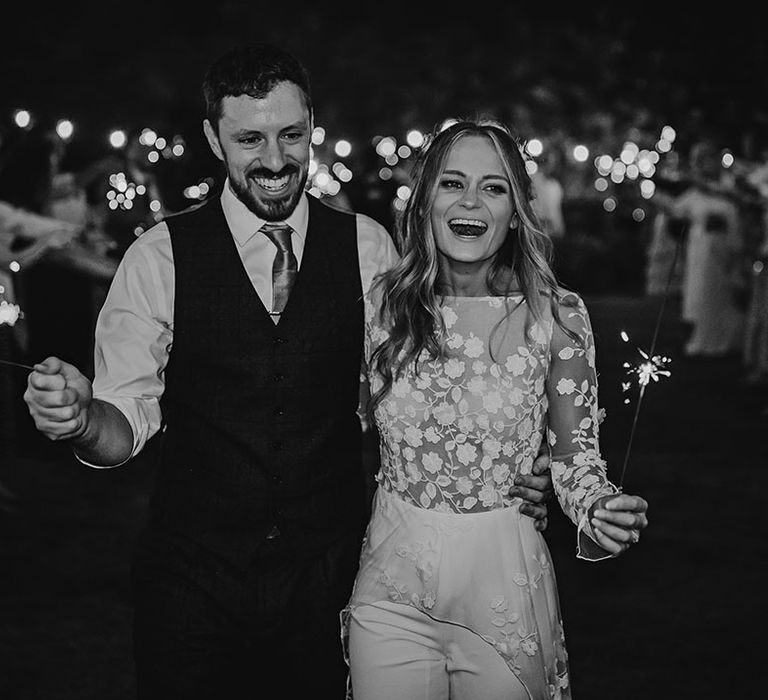 Bride in second reception look and groom have sparkler send off from their wedding 