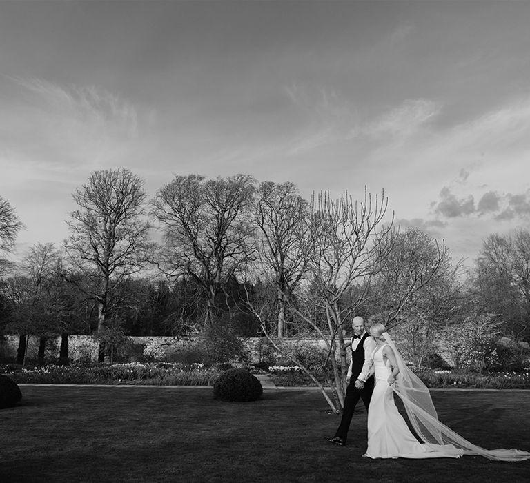 Bride and groom talk and walk hand in hand on their wedding day 