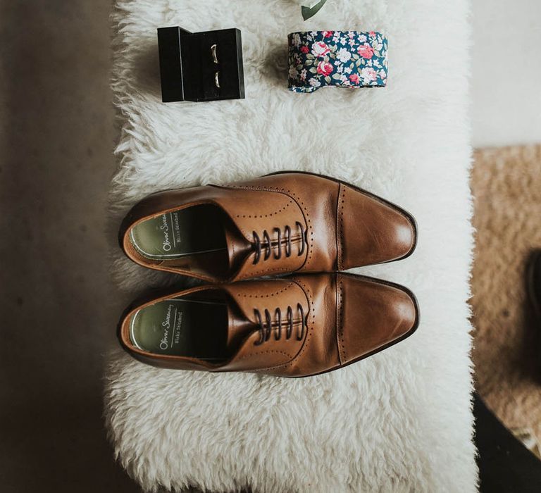 Groom's accessories with the tie, handkerchief, buttonhole, brown leather shoes, cuff links and wedding rings 