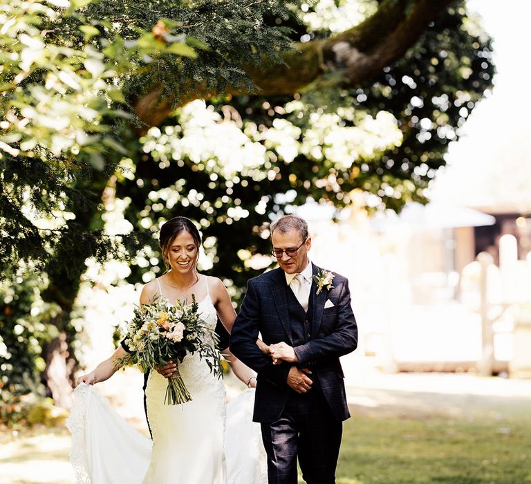 Checkered blue suit worn by father of the bride with bride in a lace wedding dress for outdoor wedding 