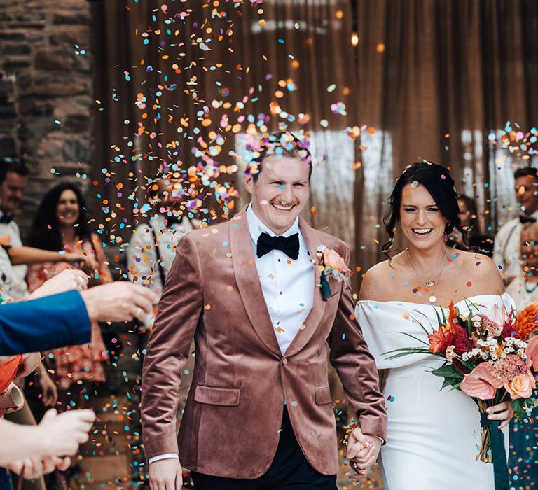 Colourful confetti exit for the bride and groom after their ceremony 