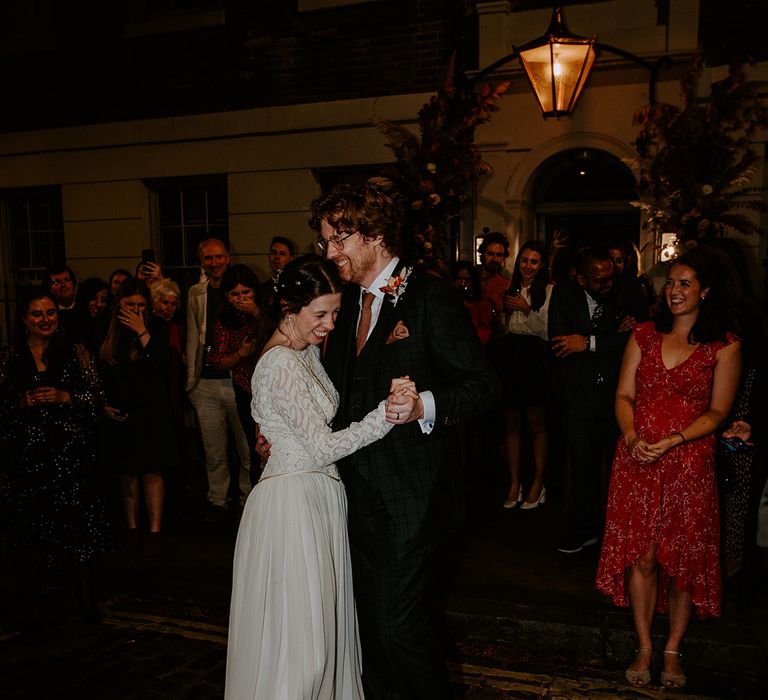 Bride and groom doing first dance at night outside The Zetter Townhouse 