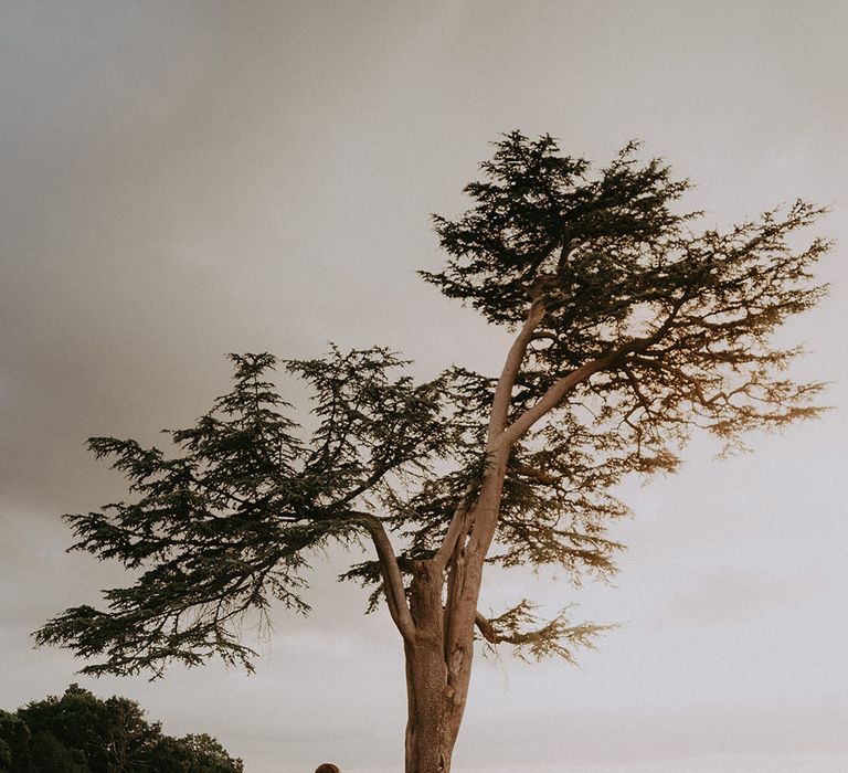 Bride & groom stand in the grounds of Hedsor House wedding venue during couples portraits