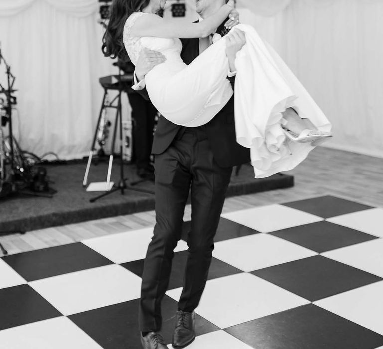 Bride and groom first dance on a black and white dance floor 