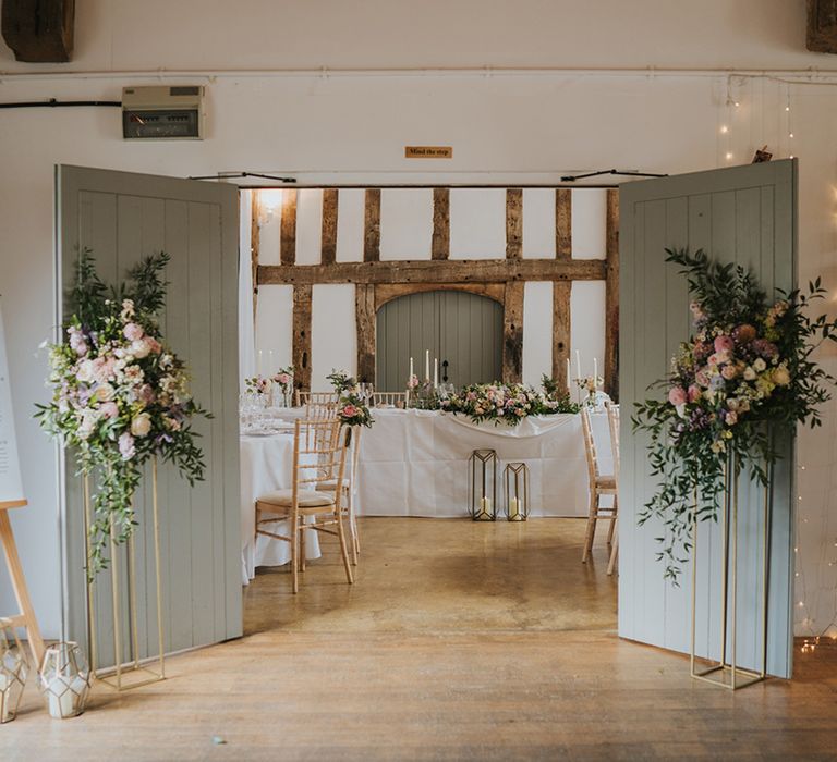 Dove Barn Weddings with the barn doors leading to the wedding reception decorated with pastel wedding flower arrangements 