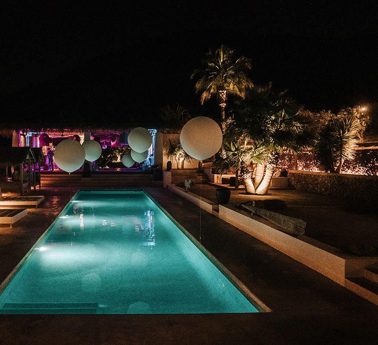 pool at night at pure house ibiza wedding venue with giant white balloons around the edge