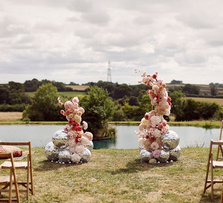 Disco balls in different sizes with pink and white flower column decorations for outdoor humanist wedding ceremony at Anran wedding venue 