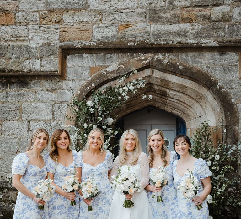 Bridesmaids in blue floral bridesmaid dresses with pastel and white wedding bouquets for spring wedding in Scotland 