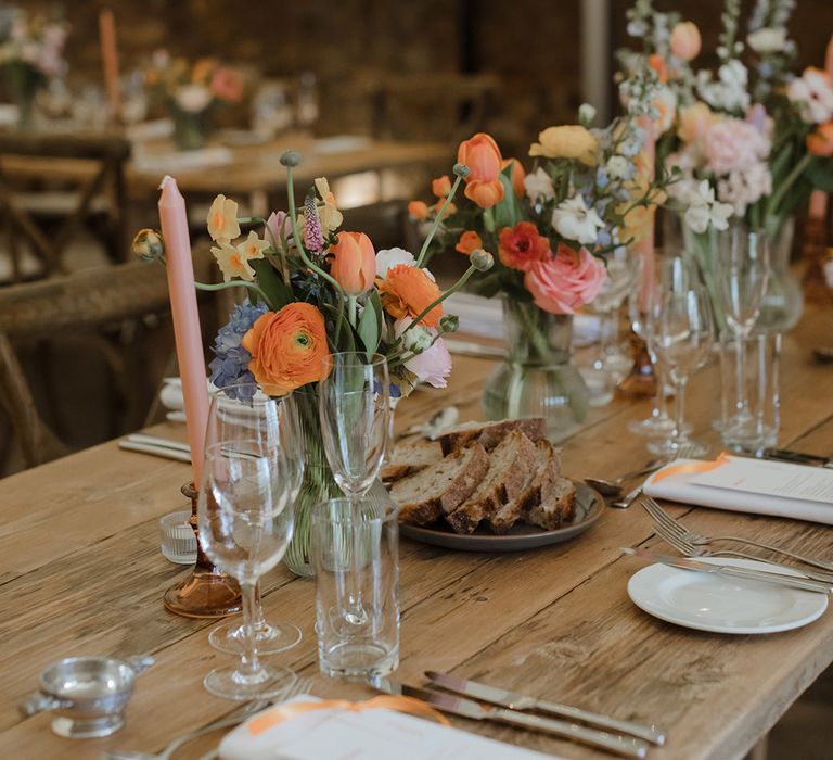 Pastel wedding candles and flowers decorating the tablescape for spring wedding theme 