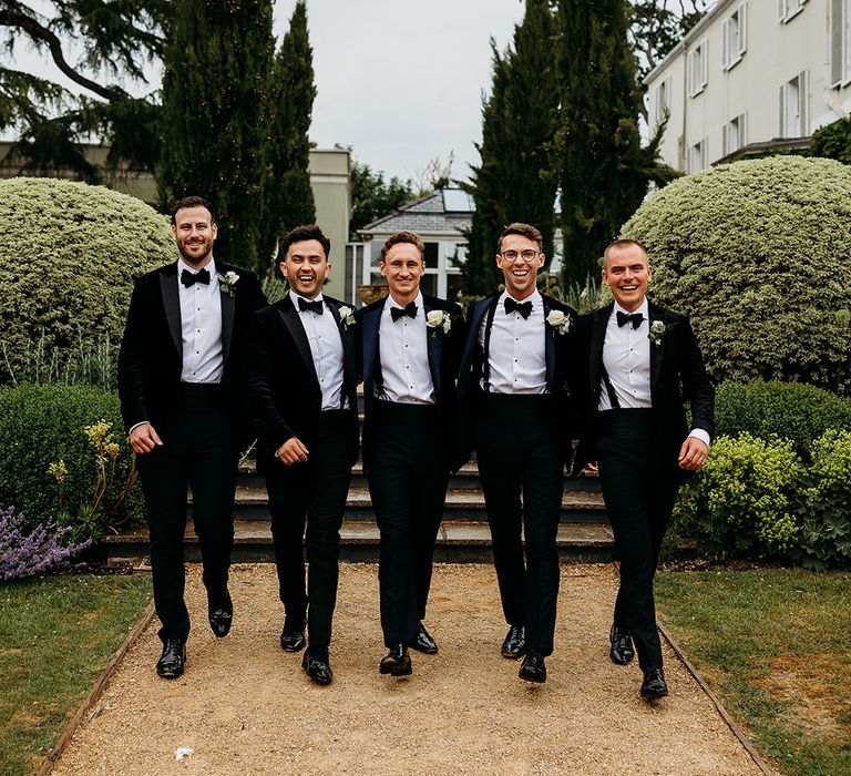 Two grooms with the groomsmen at their black tie wedding 