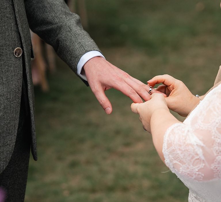 The ring exchange during the wedding ceremony with the bride putting on the groom's ring 